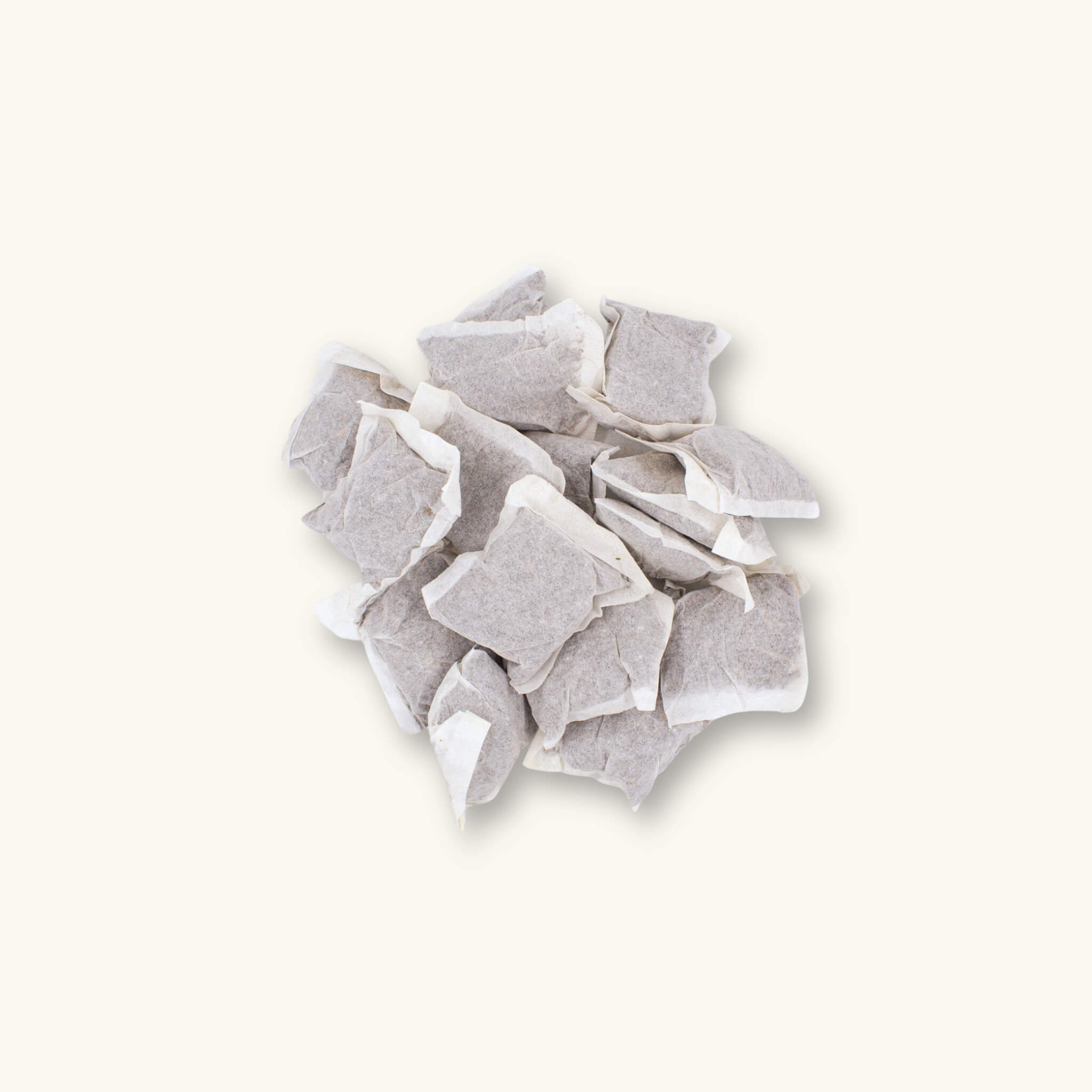A pile of 16 Betta Tea bags containing dried brown tannin producing botanicals, photographed on a natural background at Betta Botanicals.