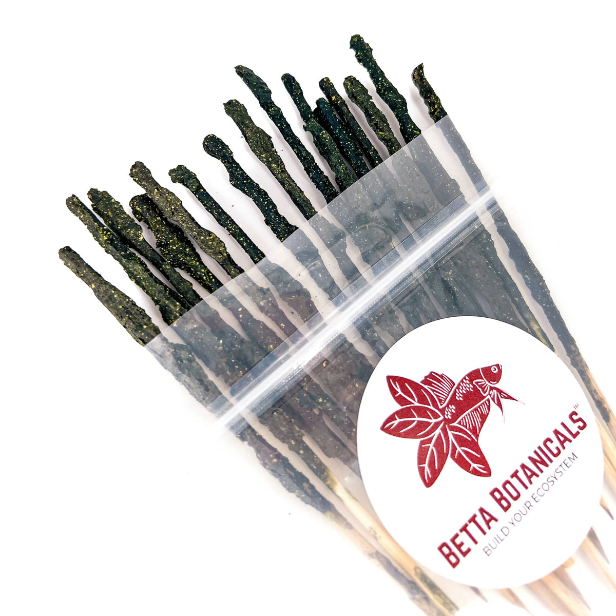 Pile of wooden skewers with green miyagi's shrimp food mix on them for aquarium shrimp in clear sustainable packaging by Betta Botanicals.