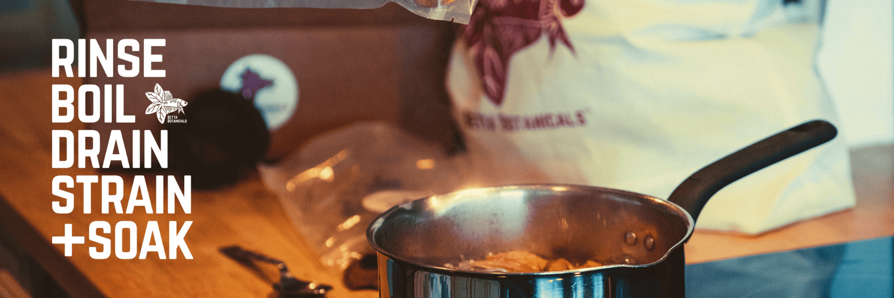 A close-up image showing a stovetop preparation of aquarium botanicals, with a metal pot filled with boiling botanicals and a bag of Betta Botanicals products in the background. The text “Rinse, Boil, Drain, Strain + Soak” is prominently displayed on the left side.