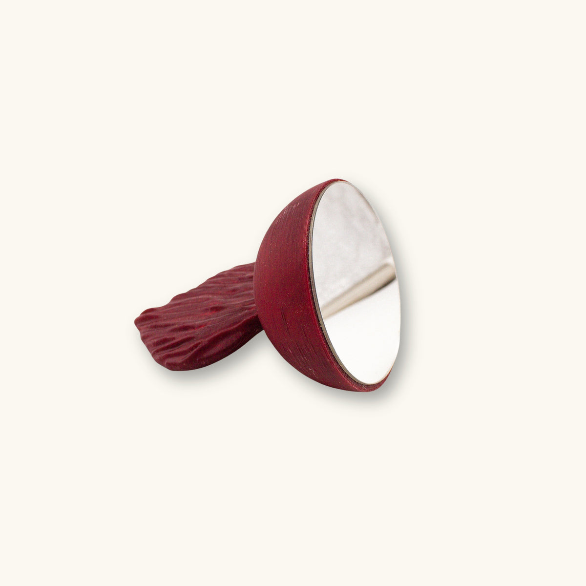 A maroon betta fish mirror for flaring, 3D printed and photographed on a natural background.