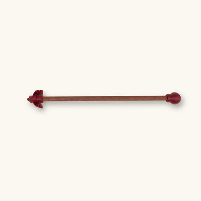 A single maroon betta fish flare stick photographed on a natural background.