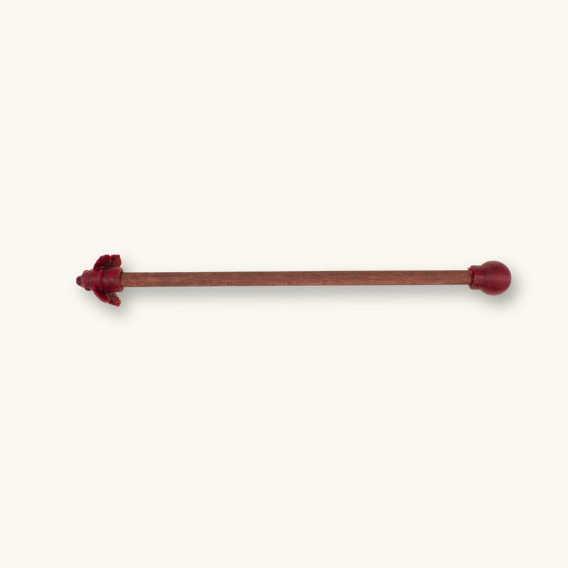 A single maroon betta fish flare stick photographed on a natural background.