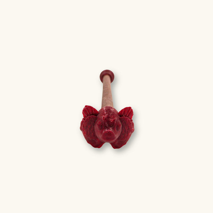 A single maroon betta fish flare stick, 3D printed and photographed on a natural background.
