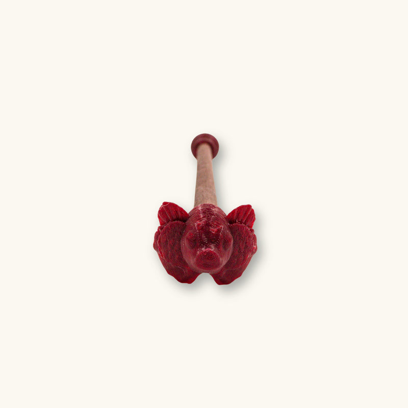 A single maroon betta fish flare stick, 3D printed and photographed on a natural background.