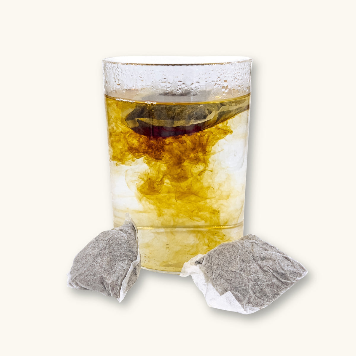 A clear glass jar with a tea bag in it releasing brown tannins for blackwater aquariums at Betta Botanicals.