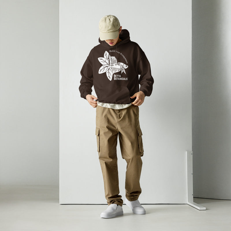 A model wearing a dark chocolate-colored Betta Botanicals hoodie featuring the ‘Build Your Ecosystem’ logo, paired with khaki cargo pants.