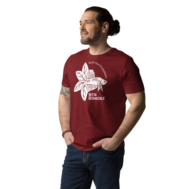 A person modeling a maroon t-shirt with the Betta Botanicals logo, featuring a stylized fish surrounded by leaves and the slogan ‘Build Your Ecosystem,’ displayed on the front.