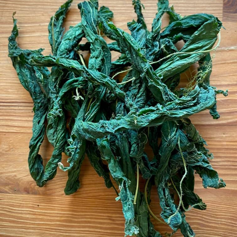 Nettle Leaves by Betta Botanicals photographed against a brown wooden table in a pile of 30.
